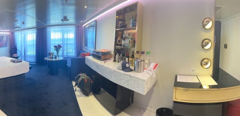 Virgin Voyages cruise ship cabin with bed, seating area, and marble minibar counter