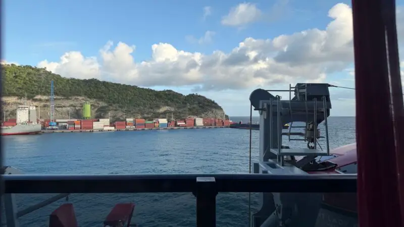 View from a Virgin Voyages cabin window of a port and container yard