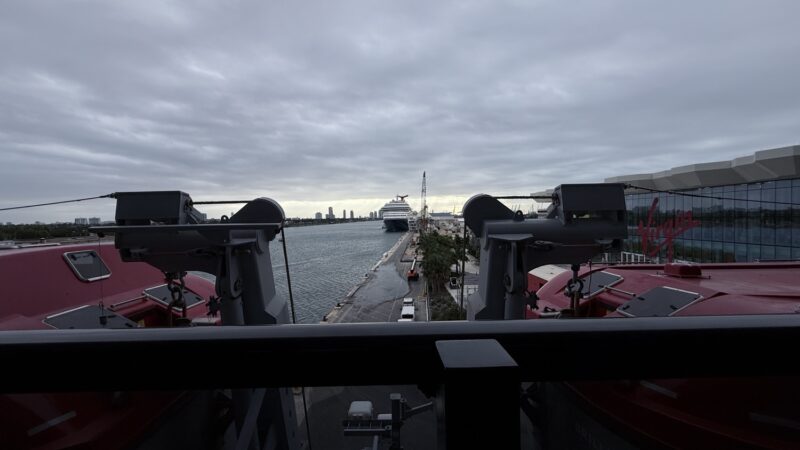 View from a Virgin Voyages cruise ship deck toward a docked cruise ship