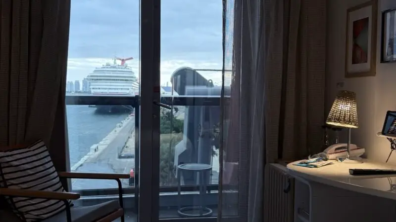 Virgin Voyages cruise ship cabin with balcony view of docked ships