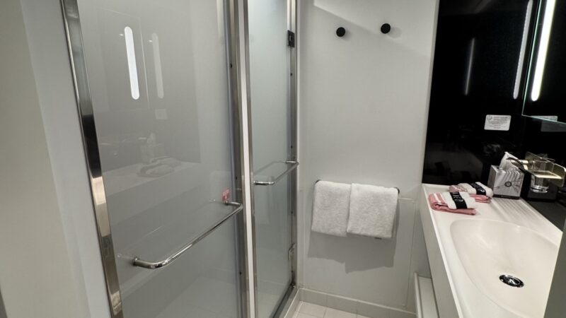 Modern cruise ship cabin bathroom with glass shower and sink on a Virgin Voyages cruise ship