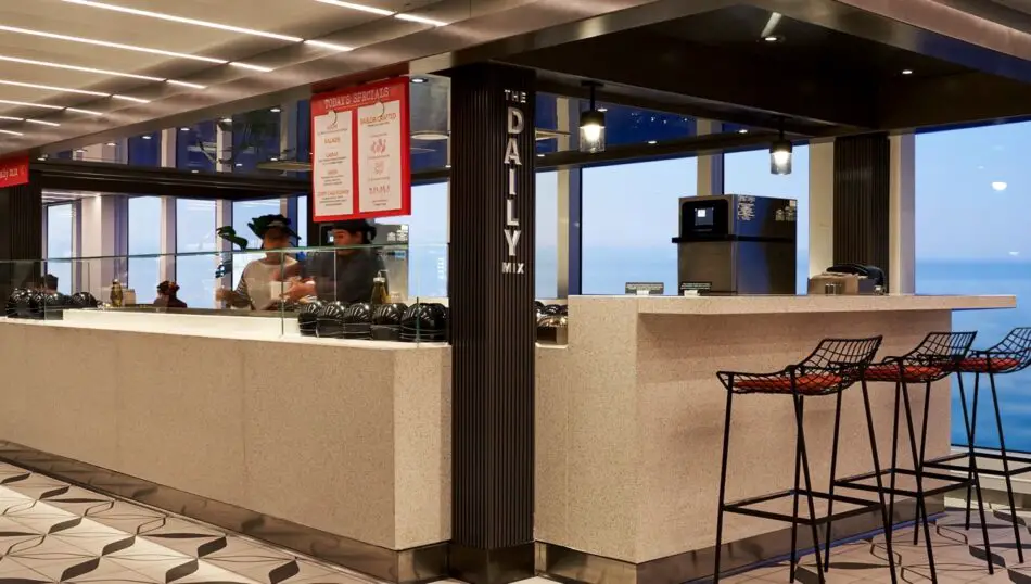 Cafe counter with stools and glass railing overlooking the ocean on a cruise ship