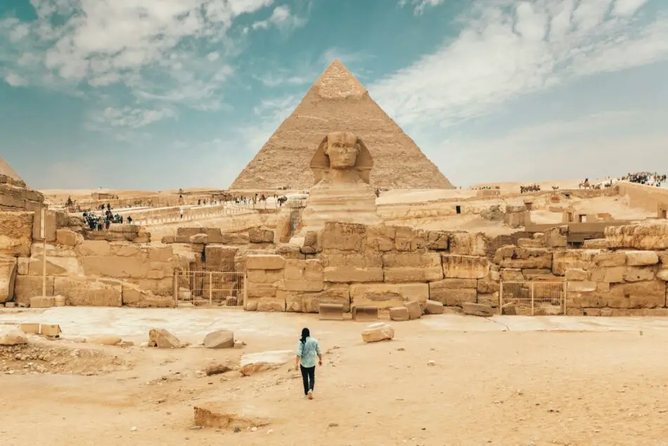Traveler walking toward the Sphinx and Great Pyramid at Giza