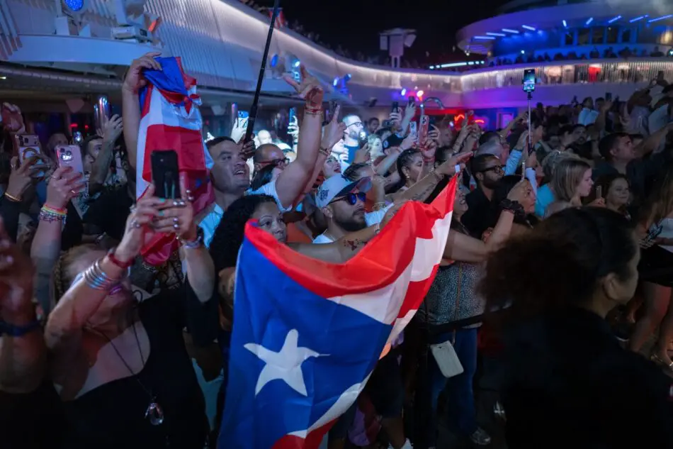 Crowd cheers with Puerto Rican flag on a Virgin Voyages cruise ship