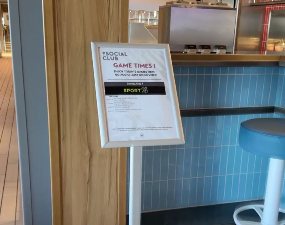 Sign listing game times at The Social Club on a Virgin Voyages cruise ship