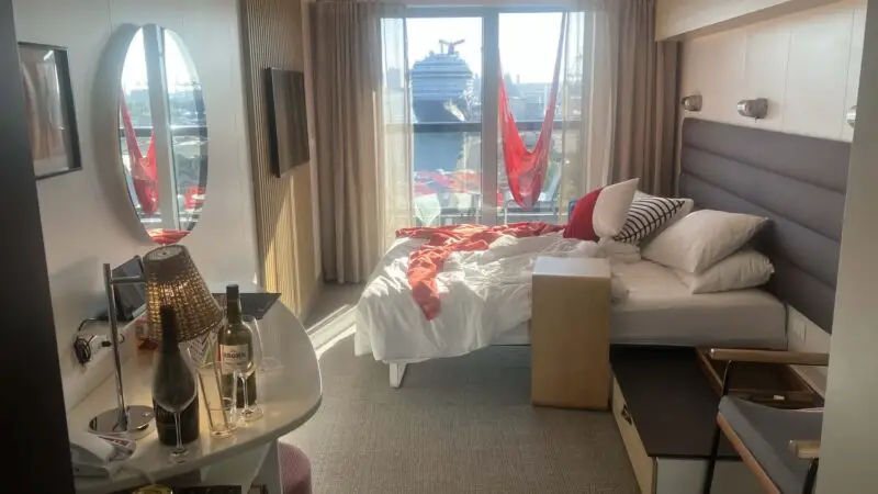 Virgin Voyages cruise ship cabin with bed and balcony view