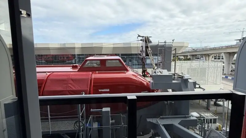 Balcony seating on a Virgin Voyages cruise ship cabin overlooking dockside equipment