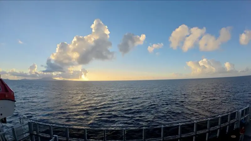 Sunset over the ocean from a Virgin Voyages cruise ship deck
