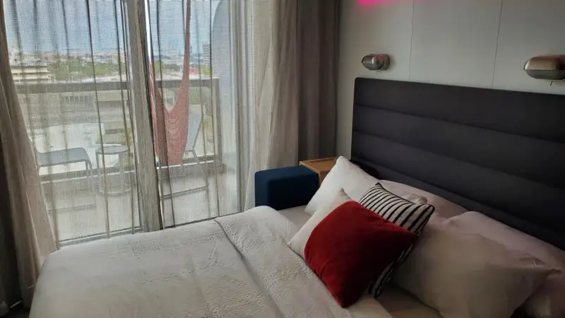 Virgin Voyages cruise ship cabin 12022Z with bed and balcony view