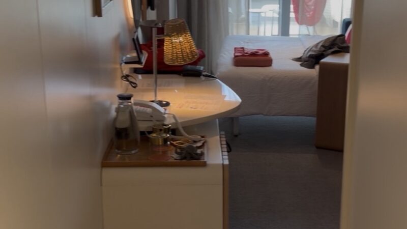 Virgin Voyages cabin with desk, bed and balcony