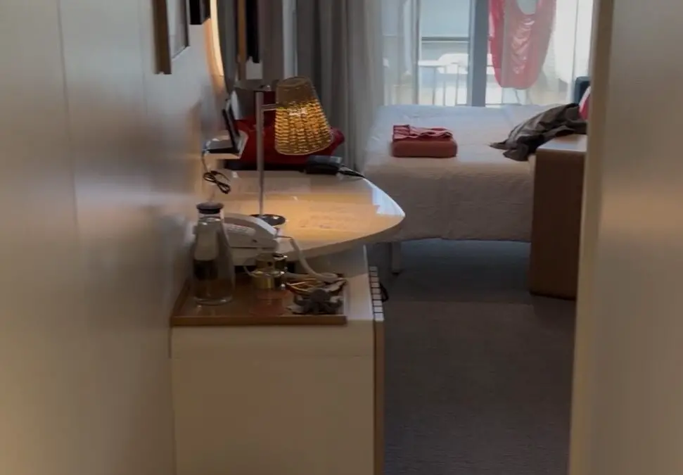 Virgin Voyages cabin with desk, bed and balcony