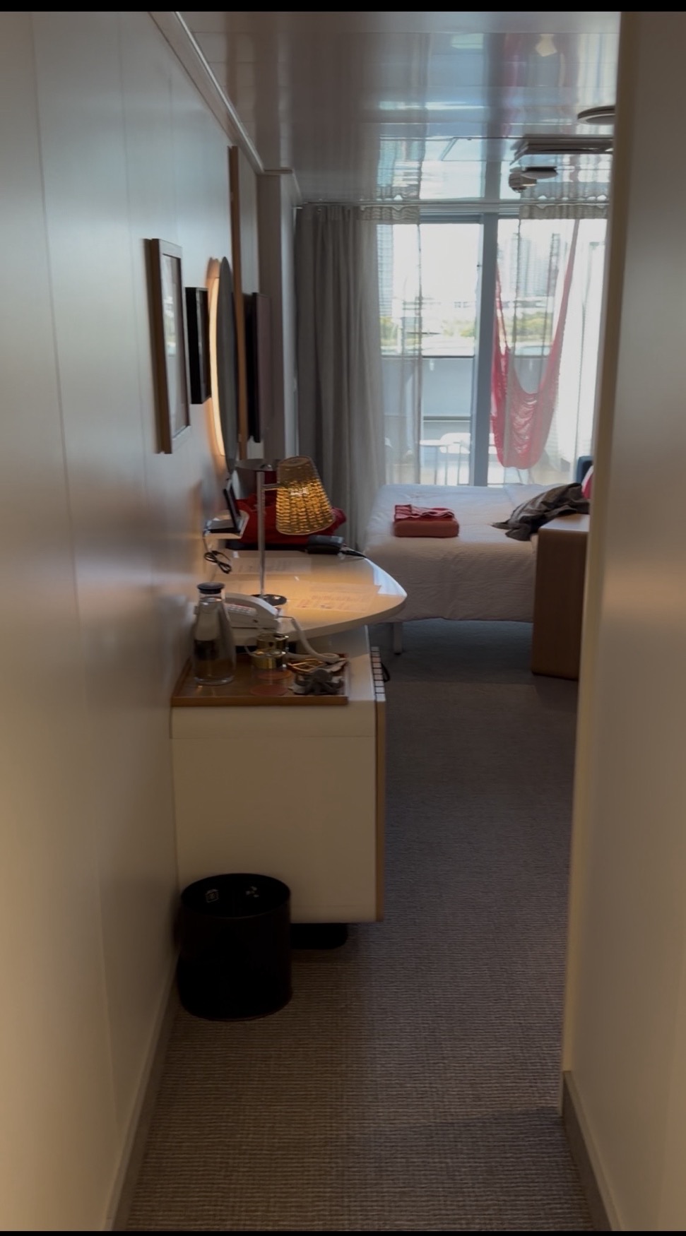 Virgin Voyages cabin with desk, bed and balcony
