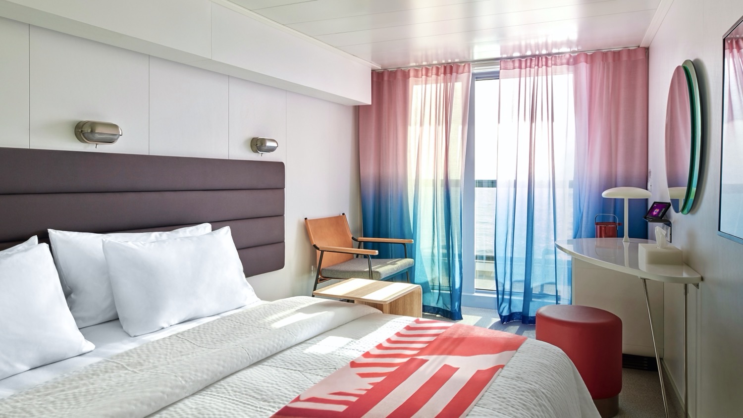Hotel-style cruise cabin with gradient pink-to-blue curtains on Virgin Voyages ship