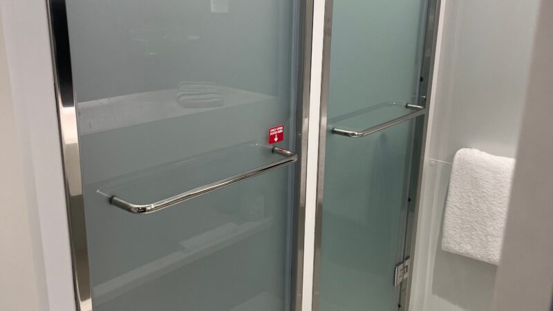 Frosted glass shower doors in a Virgin Voyages cruise ship cabin bathroom.