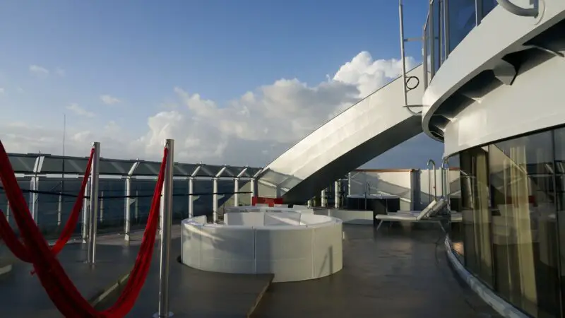 Outdoor deck lounge with red hammocks on a Virgin Voyages cruise ship