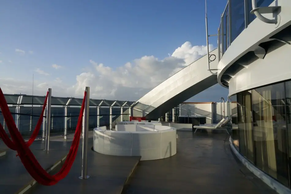 Outdoor deck lounge with red hammocks on a Virgin Voyages cruise ship