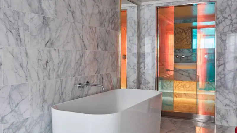 Luxurious marble bathroom with a freestanding tub on a Virgin Voyages cruise ship