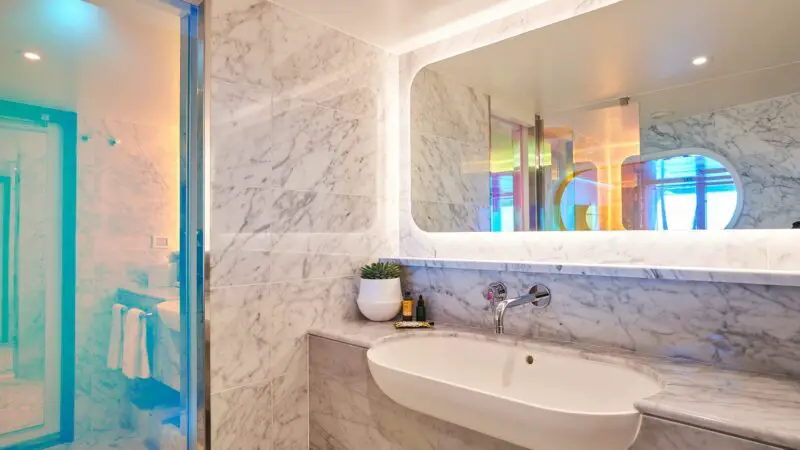 Luxurious marble bathroom aboard a Virgin Voyages cruise ship cabin