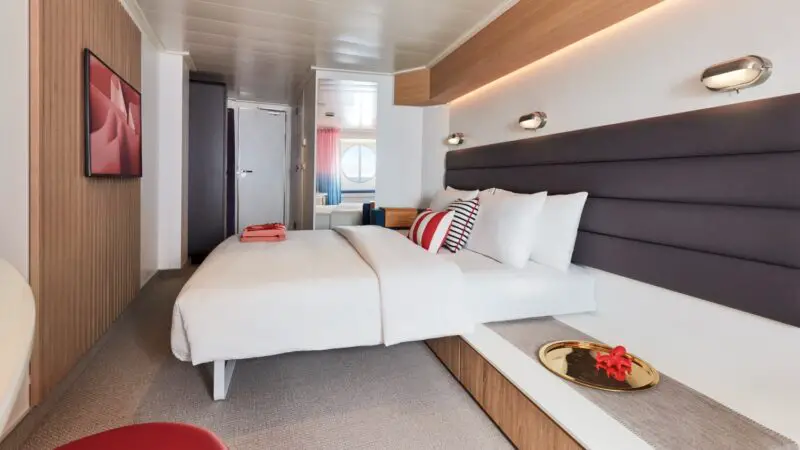 Virgin Voyages cruise ship cabin with a large bed and modern decor