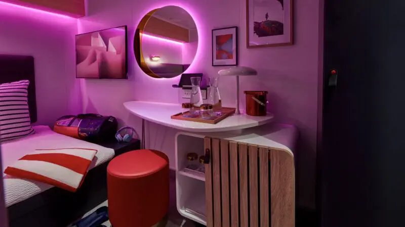 Virgin Voyages cruise ship cabin with pink ambient lighting