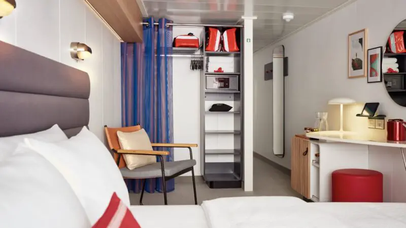 Virgin Voyages cruise ship cabin with bed, wardrobe, and desk