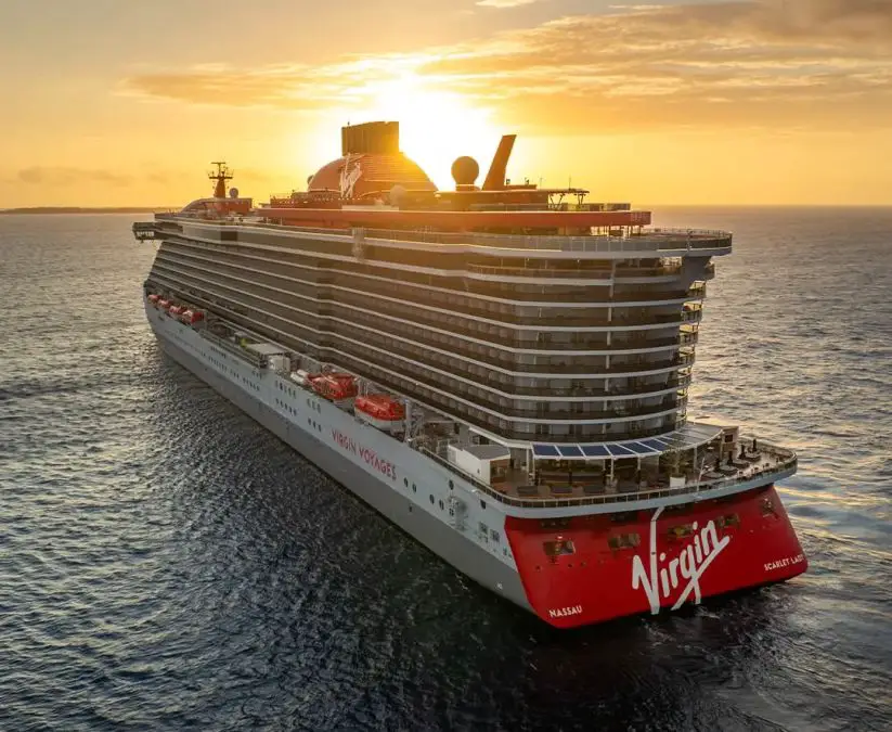 Cruise ship sailing on the ocean at sunset.