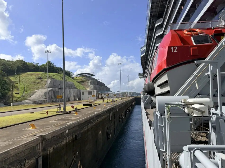 Red lifeboat on the side of a docked cruise ship at the port