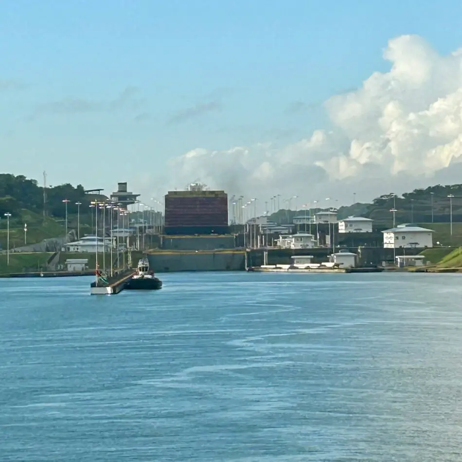 Industrial waterfront canal with lock and small buildings along shore