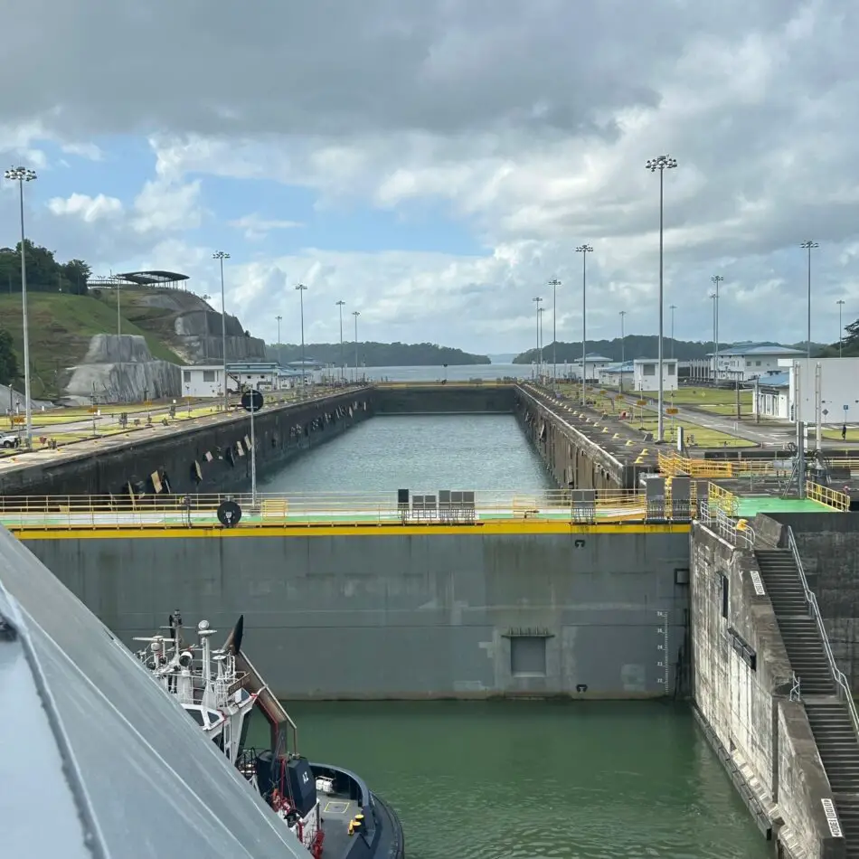 Cruise ship in a canal lock with concrete walls and open water beyond
