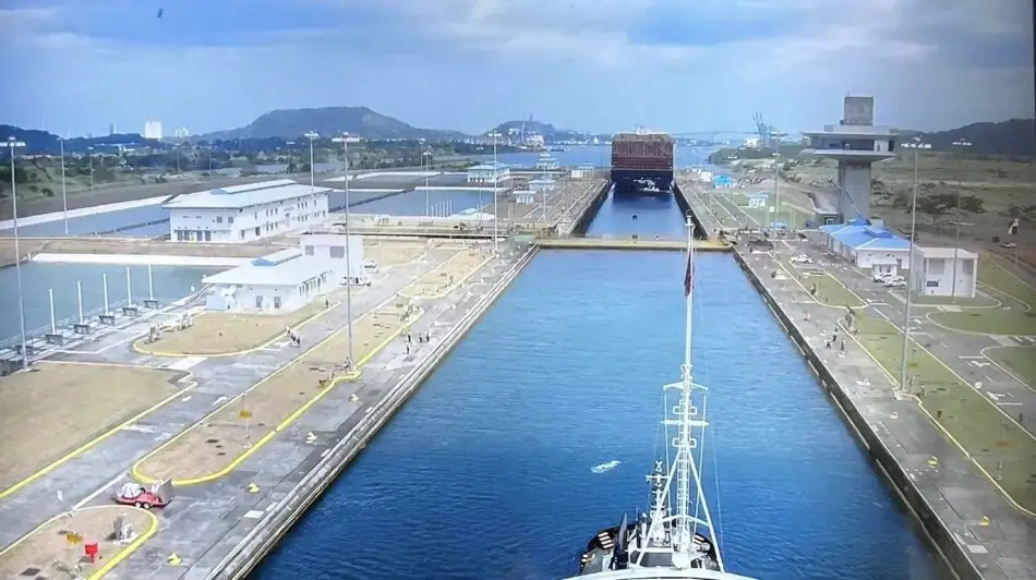 Aerial view of a ship in a canal lock surrounded by port facilities