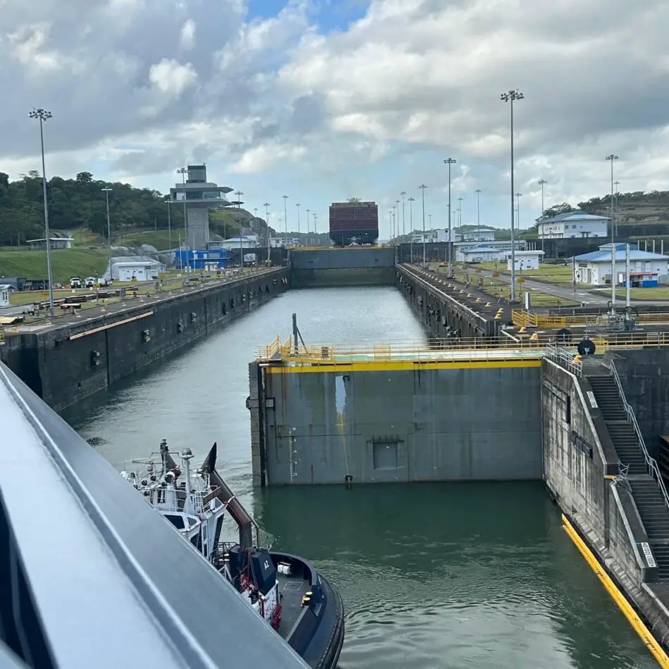 Ship in a canal lock chamber with concrete walls, gates, and a control tower