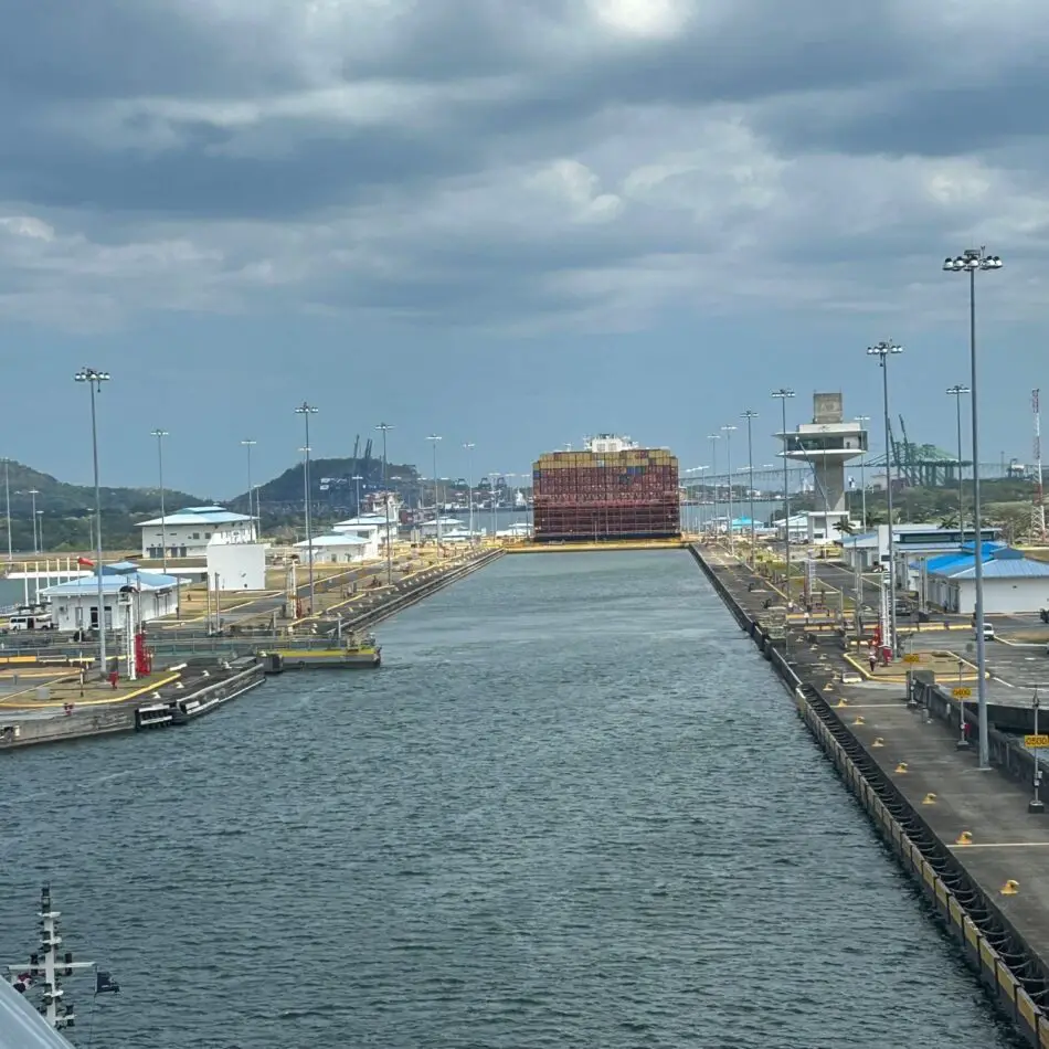 Port canal with stacked shipping containers visible at the far end