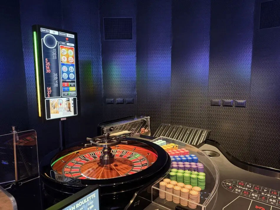 Casino roulette table with colorful chip stacks on a Virgin Voyages cruise ship