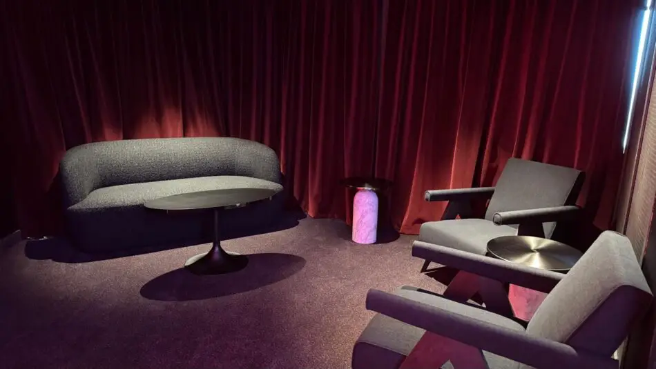 Grey seating area in a Virgin Voyages cabin on a cruise ship