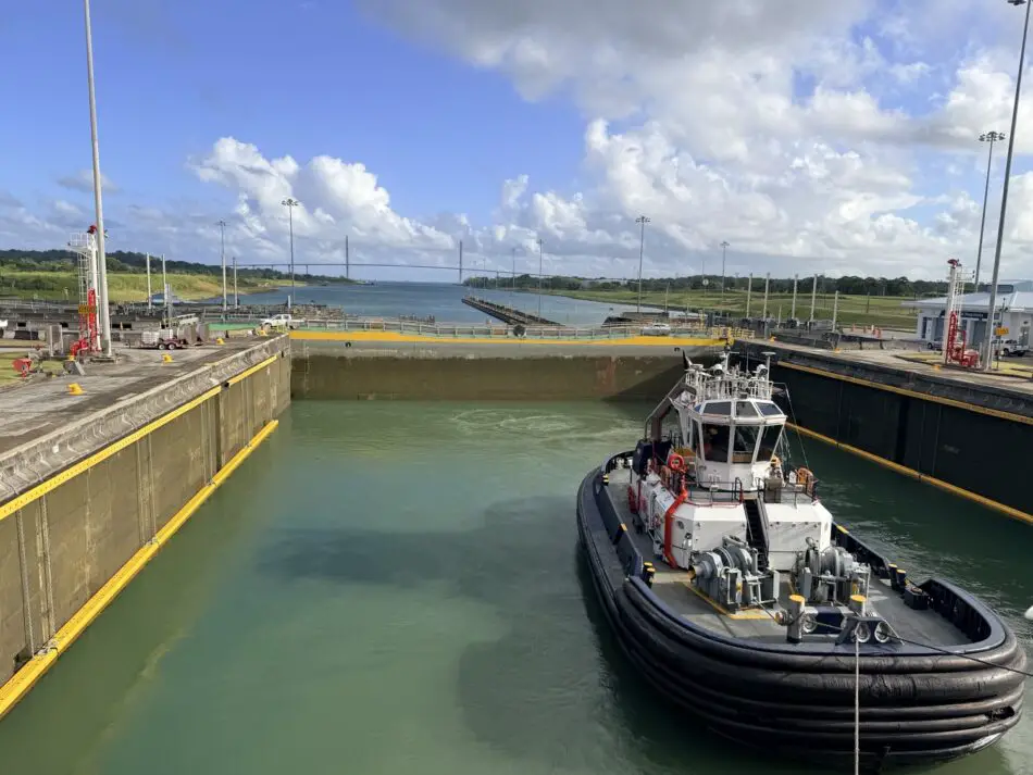 Tugboat in a port lock chamber under blue skies