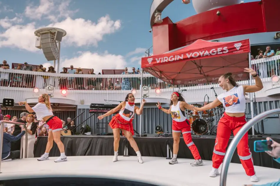 Dancers perform on an outdoor stage aboard a Virgin Voyages cruise ship