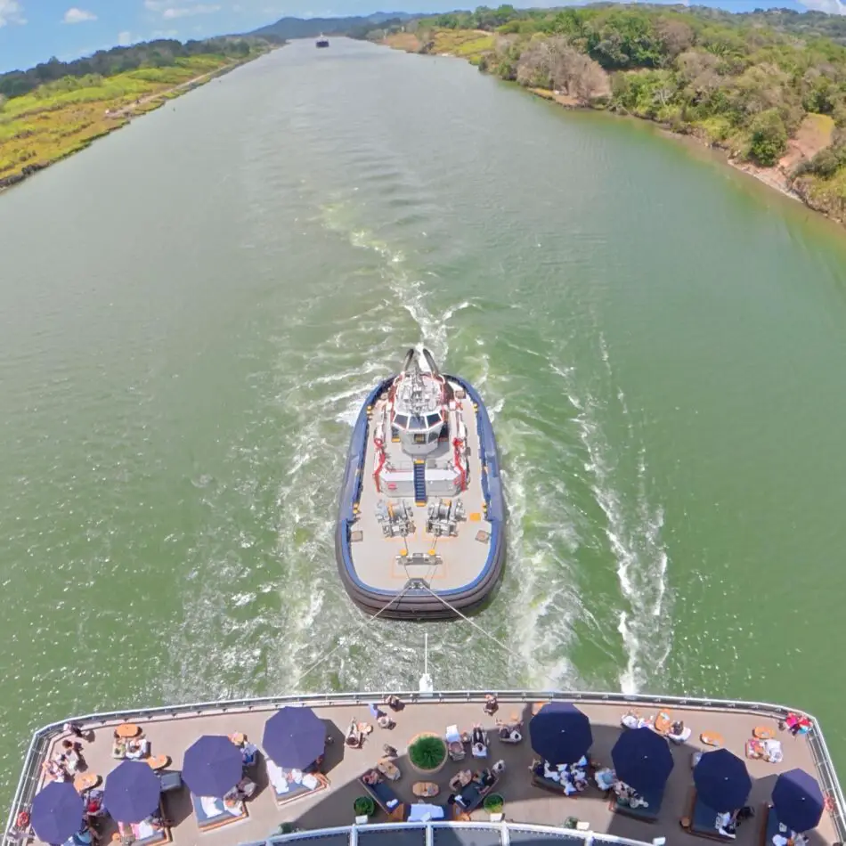A Virgin Voyages cruise ship deck viewed from above with a tender boat ahead