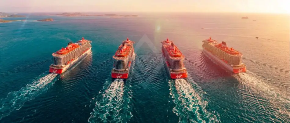 Aerial view of four Virgin Voyages cruise ships sailing in formation at sunset