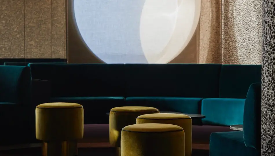 Teal upholstered sofas with yellow ottomans in a modern ship lounge