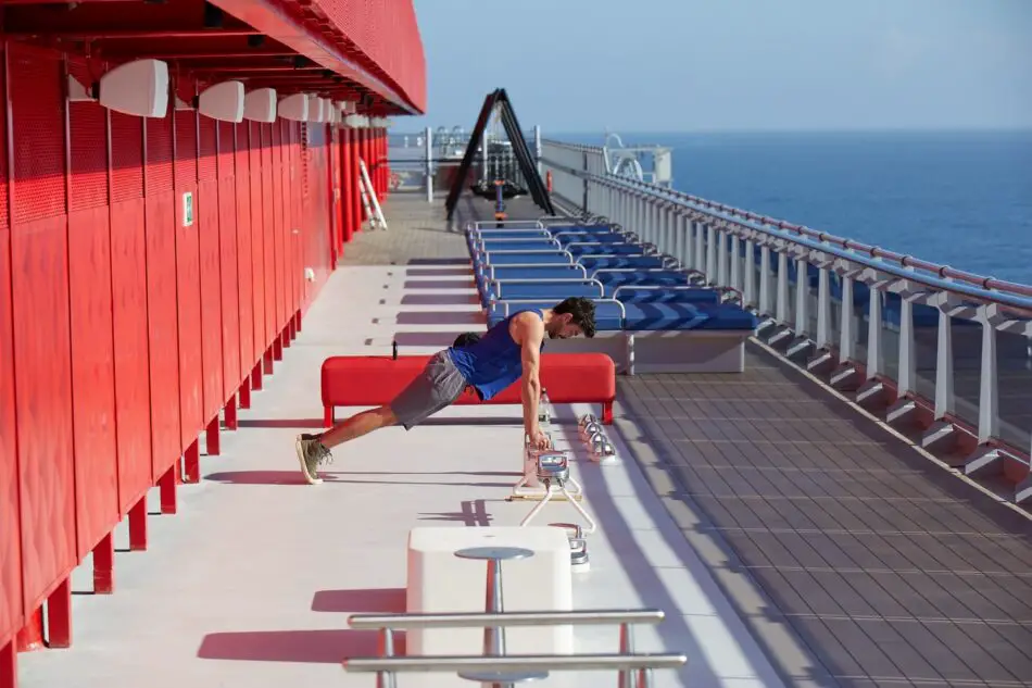 Man doing push-ups on a Virgin Voyages cruise ship deck