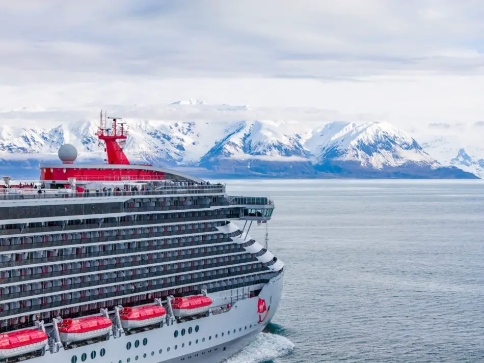 Virgin Voyages cruise ship on icy waters near snow-capped mountains