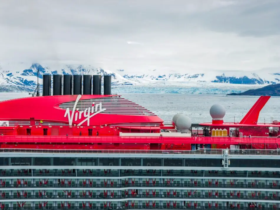 On a Virgin Voyages cruise ship with a red hull against icy mountains