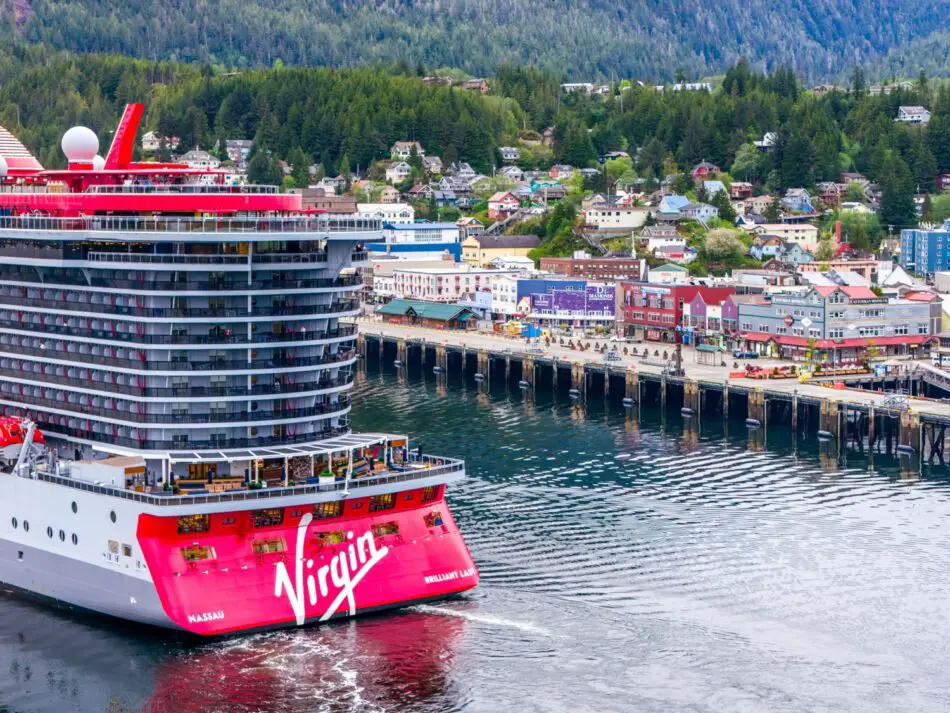Virgin Voyages Brilliant Lady docked beside colorful harbor town
