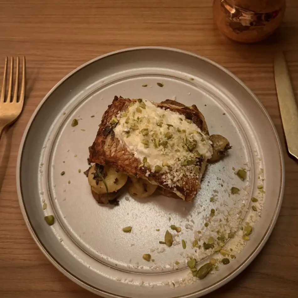 Roasted chicken with herb crust and pistachio topping served with potatoes