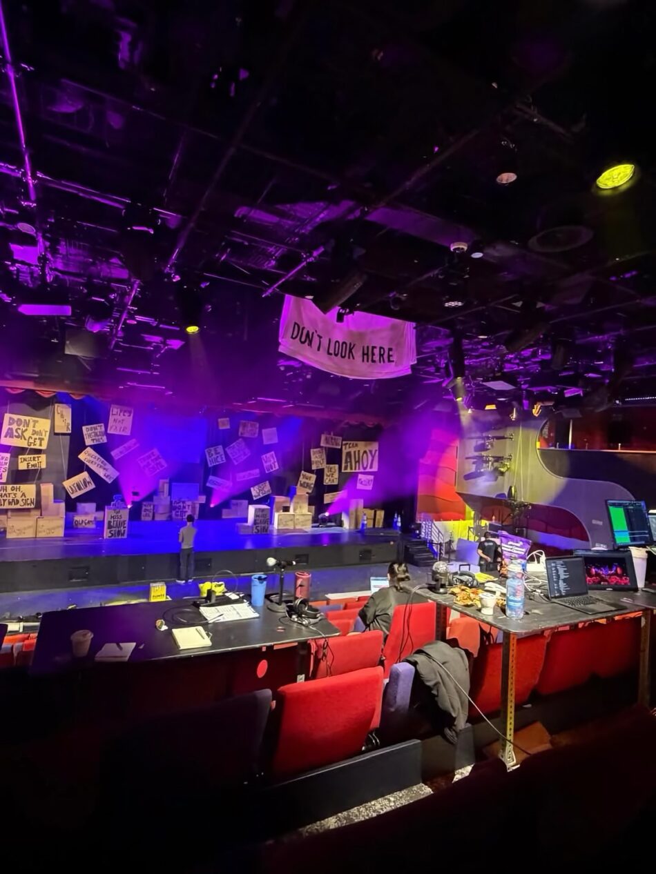 Theater stage with purple lighting and a banner reading Don't Look Here