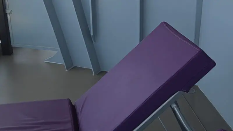 Virgin Voyages cruise ship balcony with a purple cushioned lounge chair and round table.