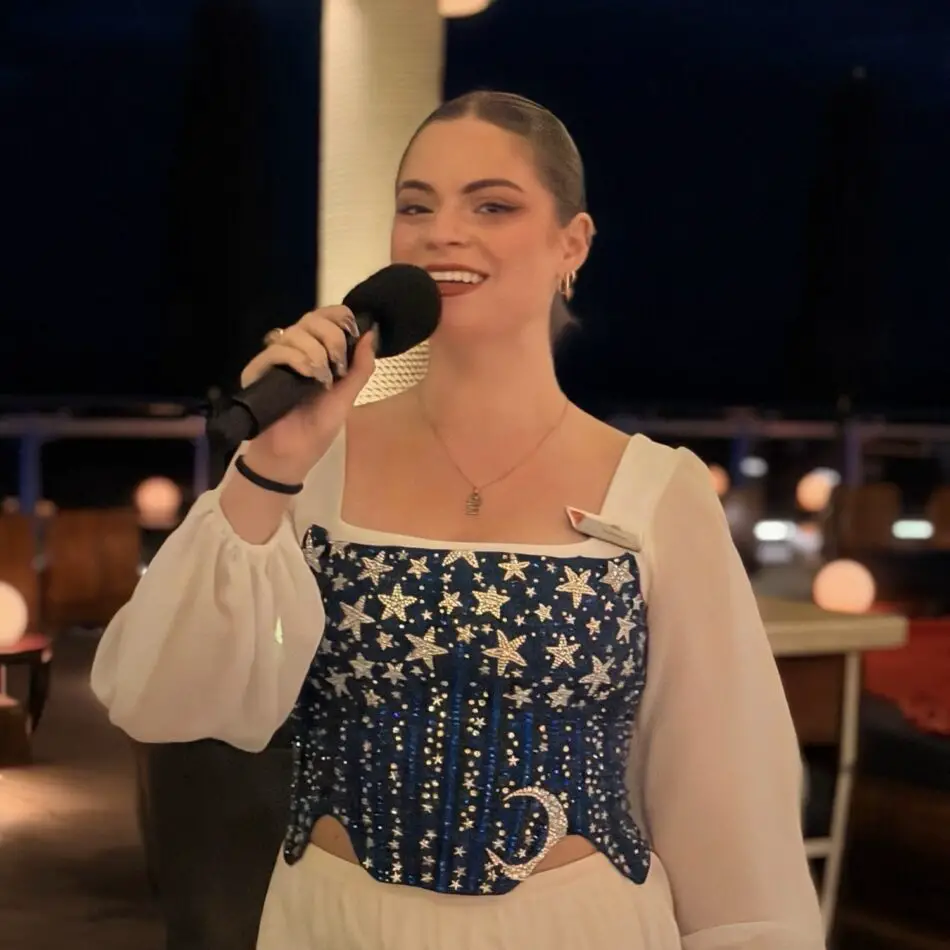 Female singer performing with a microphone on a cruise ship deck