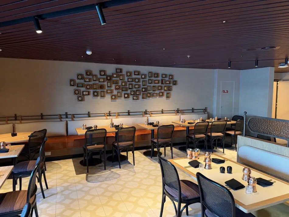 Virgin Voyages cruise ship dining area with long wall bench and tables