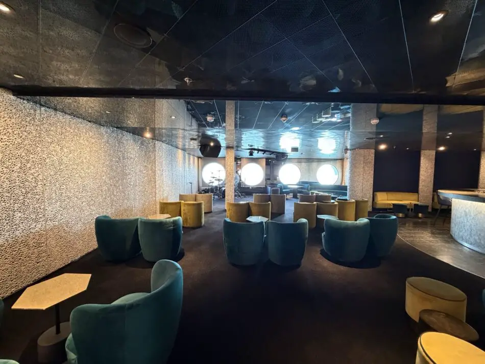 Lounge area with colorful chairs and a drum stage aboard a Virgin Voyages cruise ship