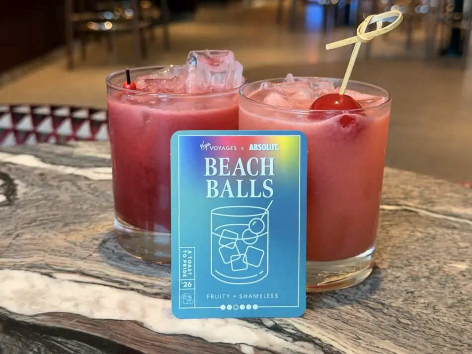 Two pink cocktails with ice and a Beach Balls card on a Virgin Voyages cruise ship